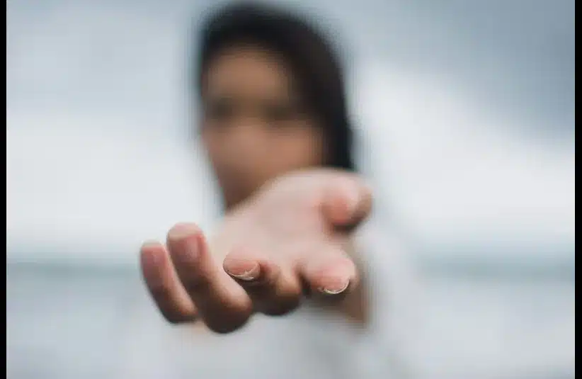 In daily devotion, a woman extends her hand.