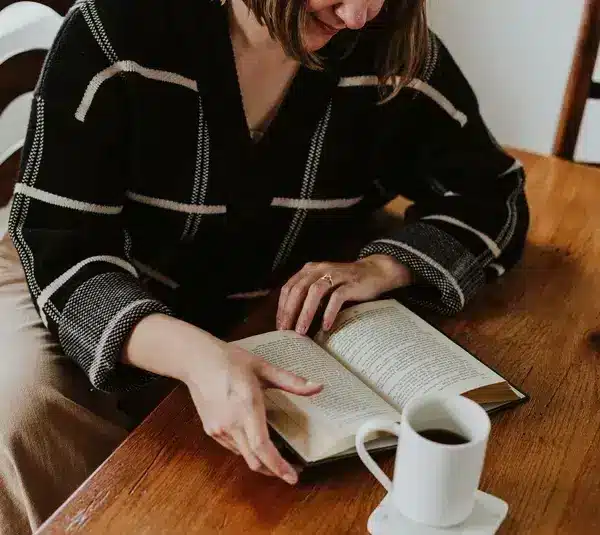 A woman reading a book in honor celebrating female authors for Women's History Month