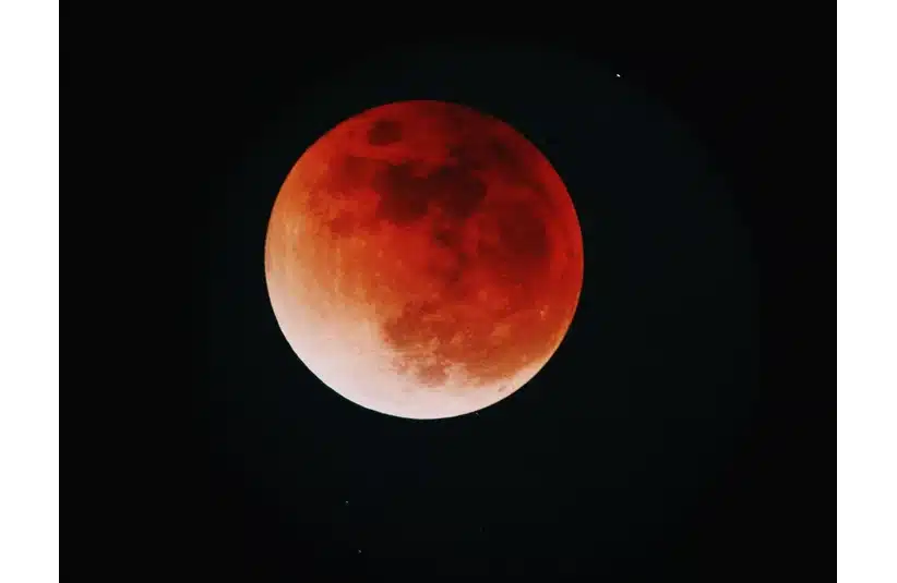 Image of the moon which appears to be red on the black background of the sky, lunar eclipse, blood moon