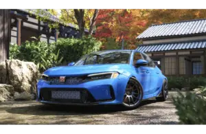 Forza Horizon 6 a Blue sporty car parked in a tranquil Japanese garden with stone path, lush greenery, and a traditional building. Vibrant autumn leaves enhance the serene setting.