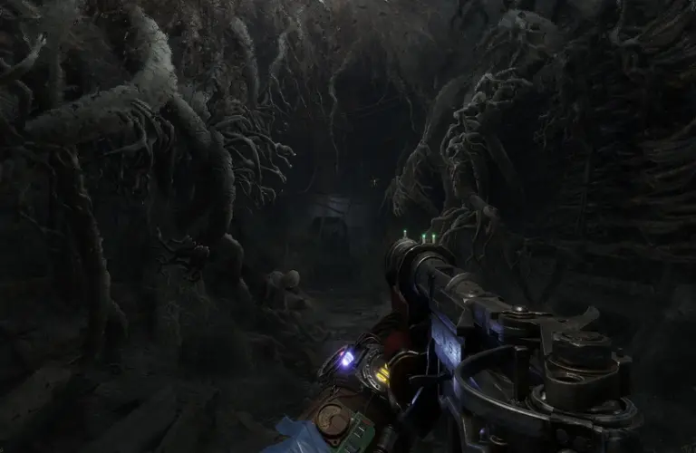 A first-person view in a dark, eerie tunnel filled with twisted roots in Metro Exodus. The scene is tense, with a gun aiming forward, illuminated by dim light. Metro 4