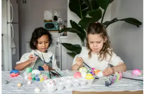 Two children dyeing Easter eggs