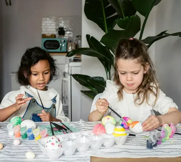 Two children dyeing Easter eggs