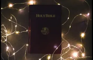 In daily devotion, a Bible is shown surrounded by wired lights.