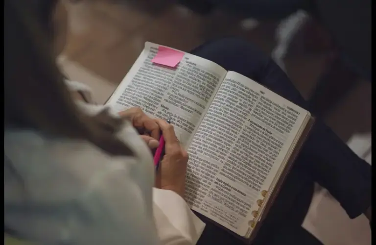 In this daily devotional, a lady reads the Bible on her lap.
