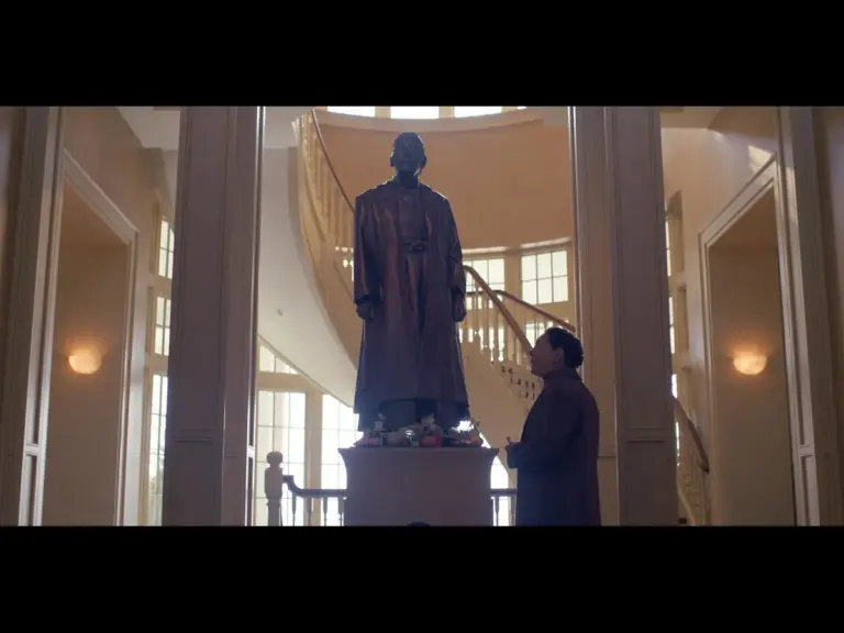 Screenshot from "The Testaments" showing the statue of Aunt Lydia 