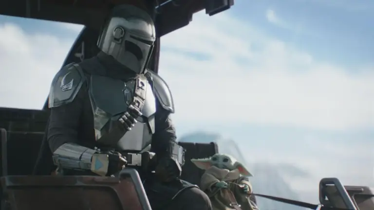 A helmeted figure in shiny armor sits beside a small, green creature with large ears. They're in a futuristic cockpit, with a serene sky in the background.