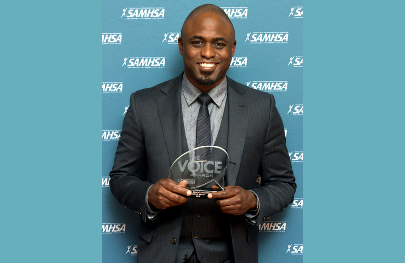 Wayne Brady holds his 2015 SAMHSA Special Recognition Award