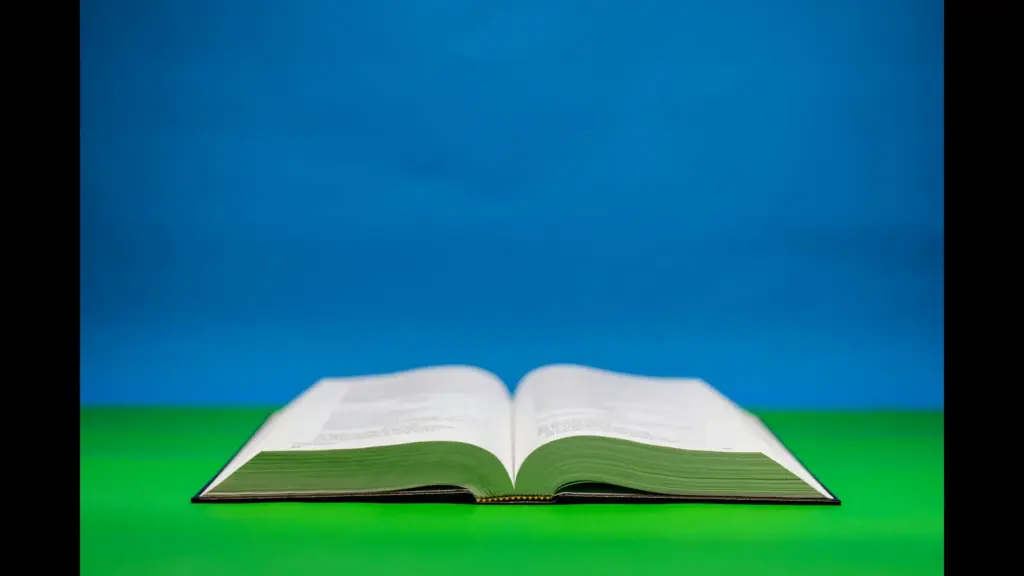 In daily devotional, an open Bible in seen with a colorful background of blue and green.