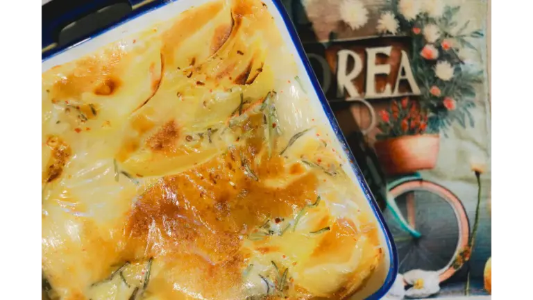 rich and creamy potatoes freshly baked, golden and crispy in a ceramic dish.