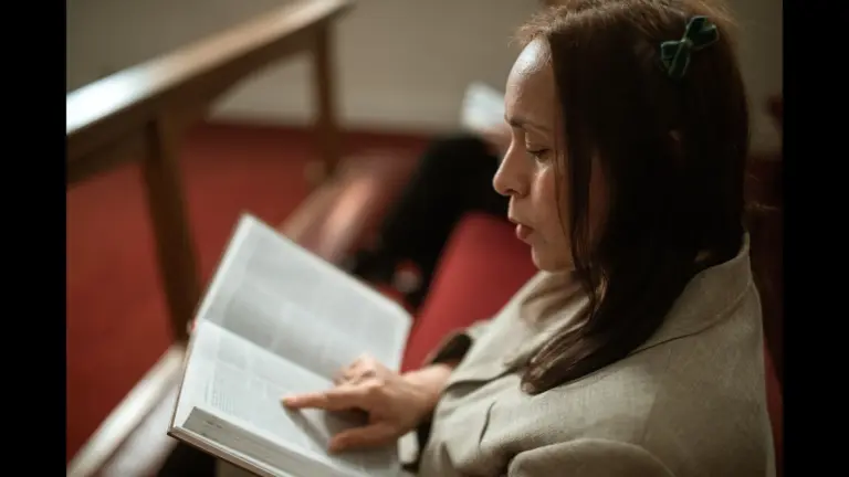 In dailly devotional, woman reads the Bible that's full of scripture on God's goodness and mercy.