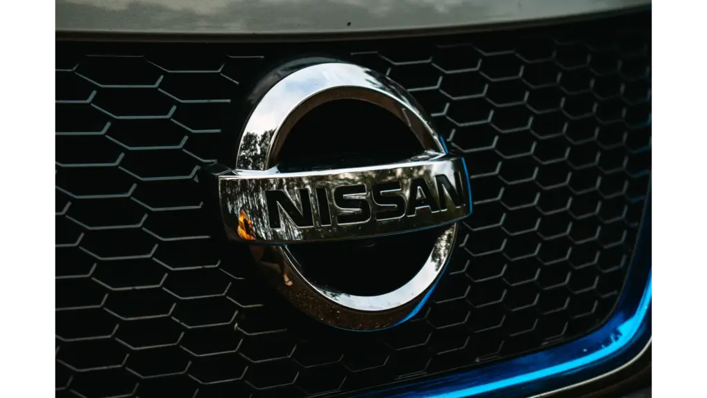 Detailed shot of the Nissan logo on a car grille grid, emphasizing automotive branding and highlighting the iconic identity of the Nissan Altima.