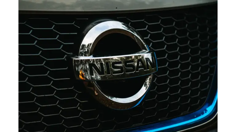 Detailed shot of the Nissan logo on a car grille grid, emphasizing automotive branding and highlighting the iconic identity of the Nissan Altima.