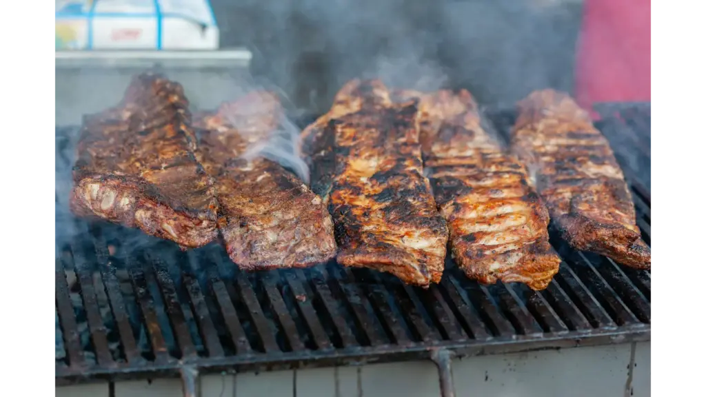Close-up of delicious grilled smoked ribs smoking on a barbecue grill, perfect for a summer cookout