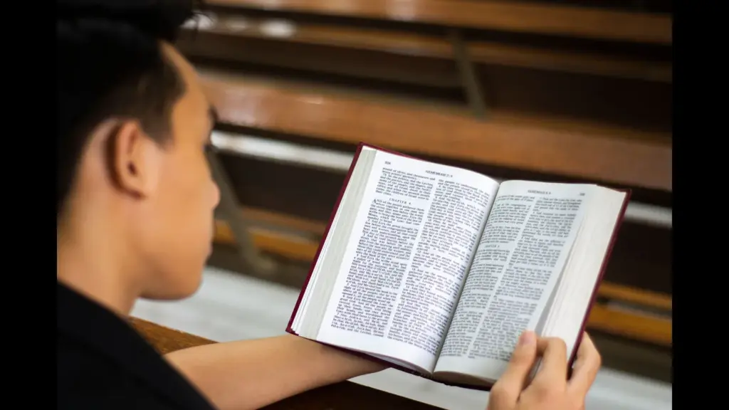 In this daily devotional, a young man reads the Bible on a pew.