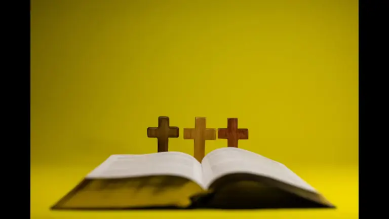 In today's daily devotional, an open Bible is pictured with 3 crosses in the center on a golden yellow background.