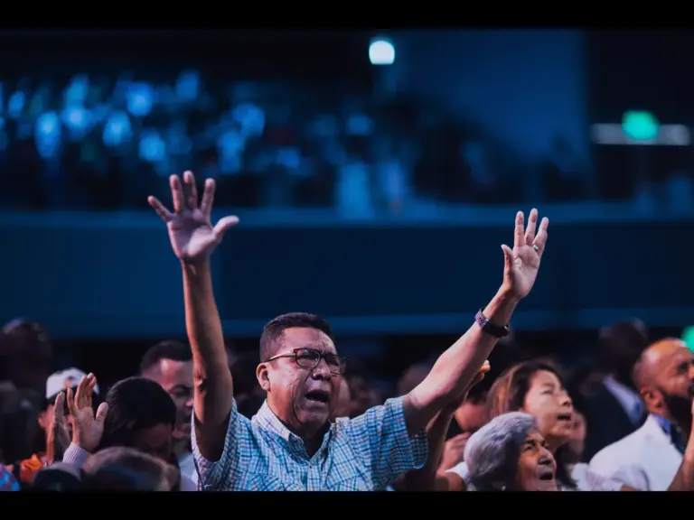 In Wednesday's daily devotional, a man is shown lifting his hands high in a worhip service at church,  surrounded by other worshippers.