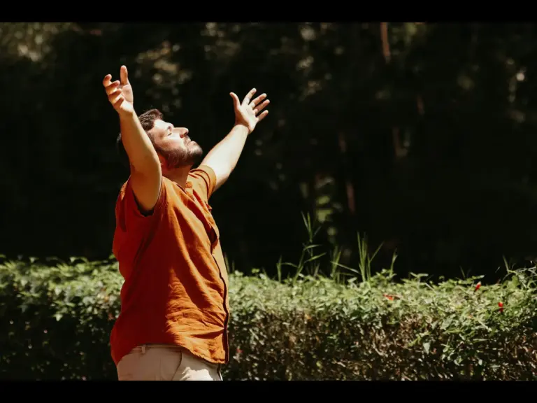 In Monday's daily devotional, a man stands outside and  lifts his arms as in casting his care upon the Lord. 