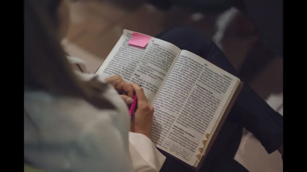 In Thursday's daily devotional, a woman studies the Bible, which has a sticky note on one side.