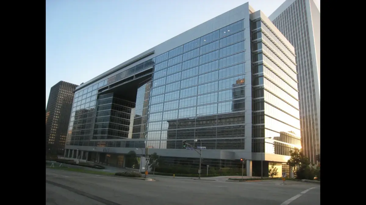 A modern glass office building reflecting the surroundings in a city setting. Creative Artists Agency (CAA), Dasha Smith