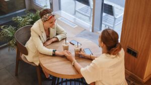 Friends talking in a coffee shop, one way to cope with loneliness through connection