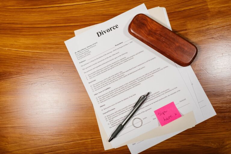 Divorce papers with a pen and a ring on a wooden desk, illustrating the Gabe Brown divorce