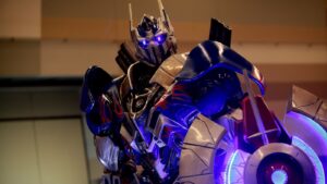 Optimus Prime statue representing the Transformers franchise behind the Kiss Players 20th anniversary set