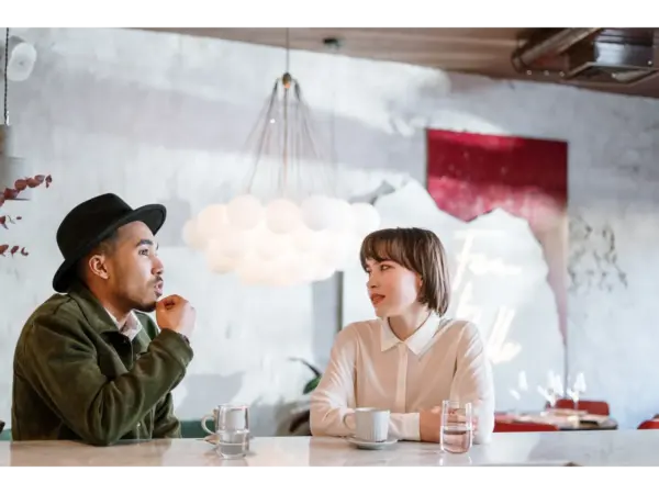 Meet cute romance moment as two adults engage in a casual conversation inside a stylish indoor café setting