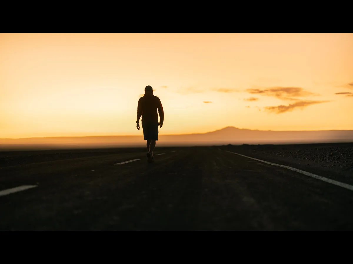 In Tuesday's daily devotional, a man's silhouette is seen walling at sunset.