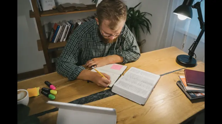 In today's daily devotional, a man is intently studying the Bible at a desk with other study tools.