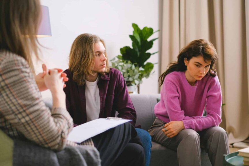 A couple talks with a therapist during a session, one way partners work to rebuild trust after lying